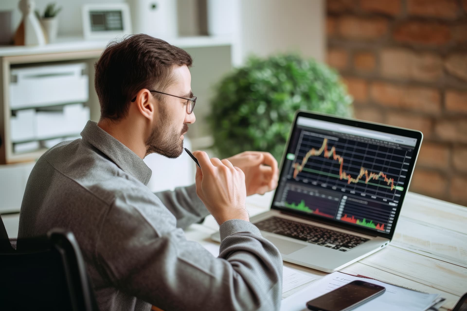 Mann mit Brille prüft Finanzdaten auf einem Laptop